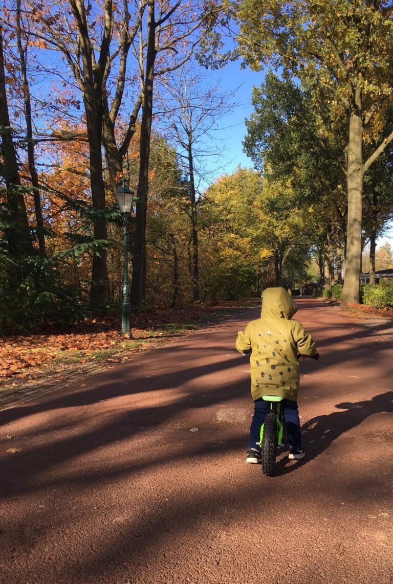 Kind op fiets op fietspad op zonnige dag tijdens Nederlandse herfst