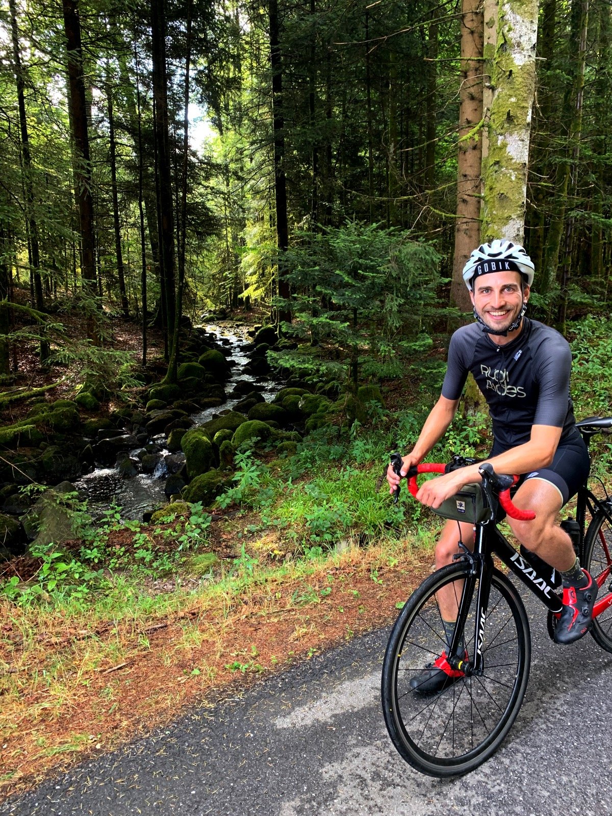 Rudi Rides fietser op fiets in het bos voor een rivier
