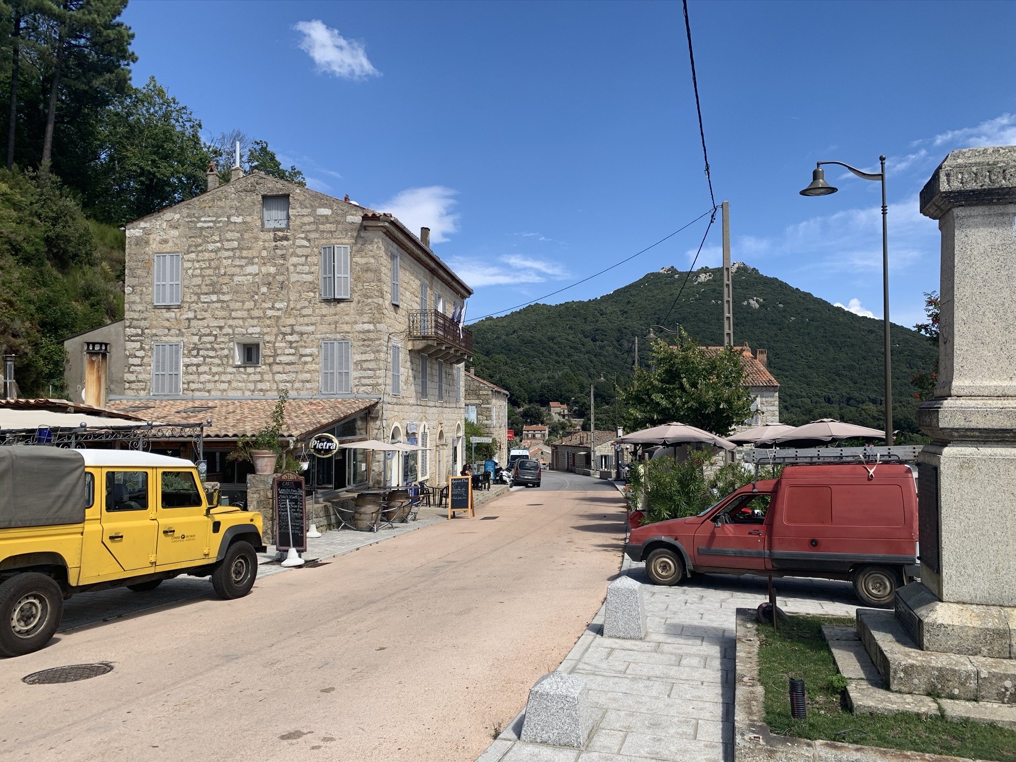 Klein verlaten dorp met enkele auto's in het binnenland van Corsica