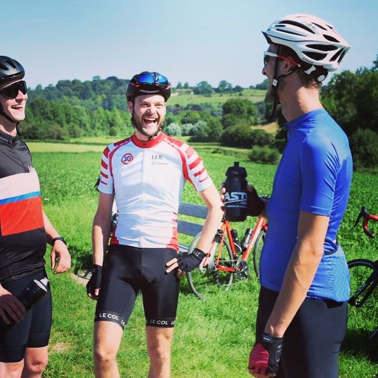 Drie wielrenners tijdens pauze lachen in Limburgse heuvels in Nederland