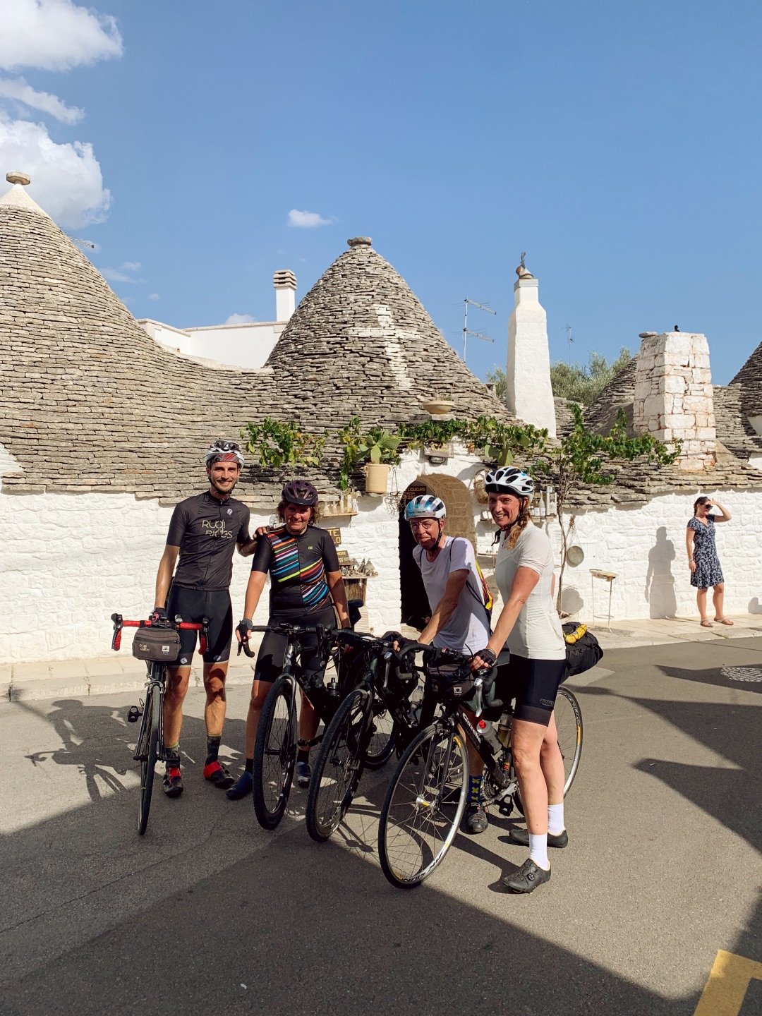 Groep fietsers van Rudi Rides voor trulli in hoofdstad van trulli Alberobello