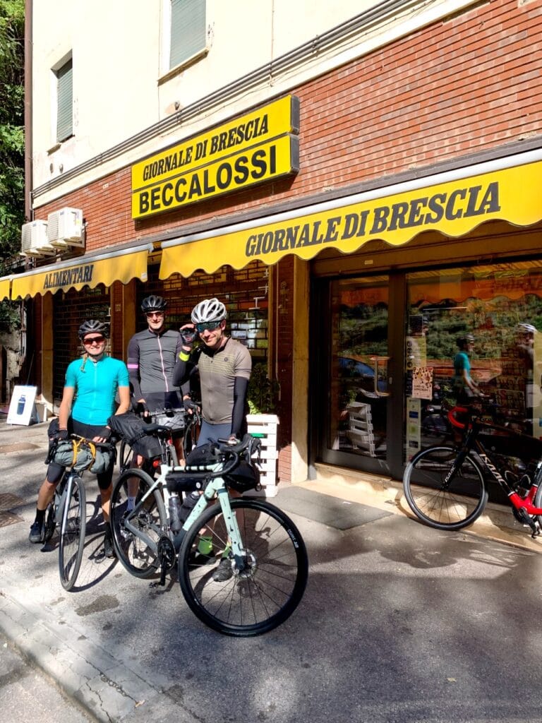 Fietsers in regio Brescia voor een Tabaccheria aan de start van een fietstocht in de Italiaanse Alpen