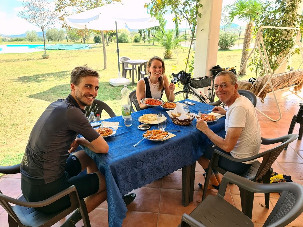 Groepsfoto tijdens een Italiaanse lunch in Zuid-Italië met deelnemers van Rudi Rides fietsvakanties