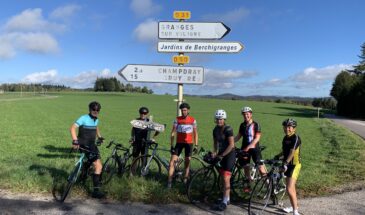 Groep fietsers van Rudi Rides in de zon voor verkeersbord in Frankrijk in de Vogezen