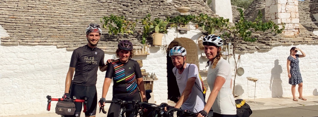 Groep fietsers van Rudi Rides voor trulli in Alberobello Zuid Italië