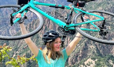 Vrouw in Bianchi fietskleding houd Bianchi fiets in de lucht op Corsica