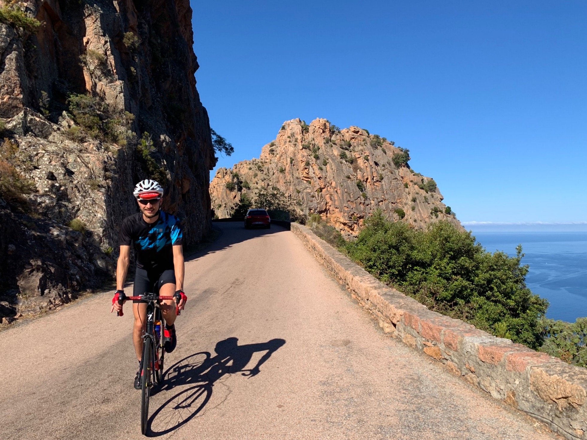 Een fietser van Rudi Rides fietst langs Calanches de Piana op Corsica