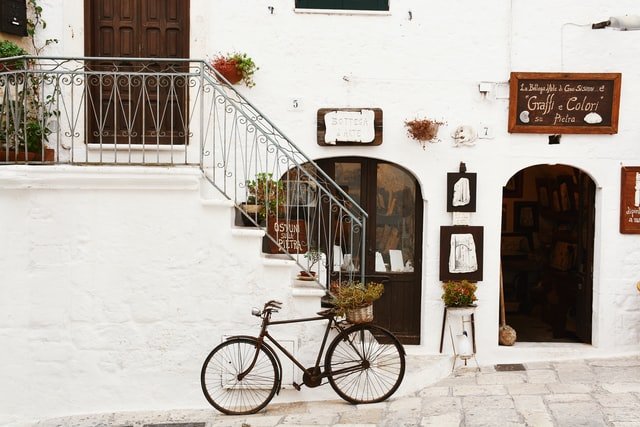 Oude fiets tegen witte muur in Zuid Italiaanse stad Ostuni