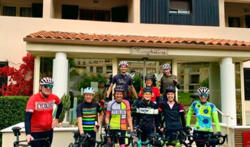 Groep wielrenners met fiets poseren voor hotel Tettola in St Florent