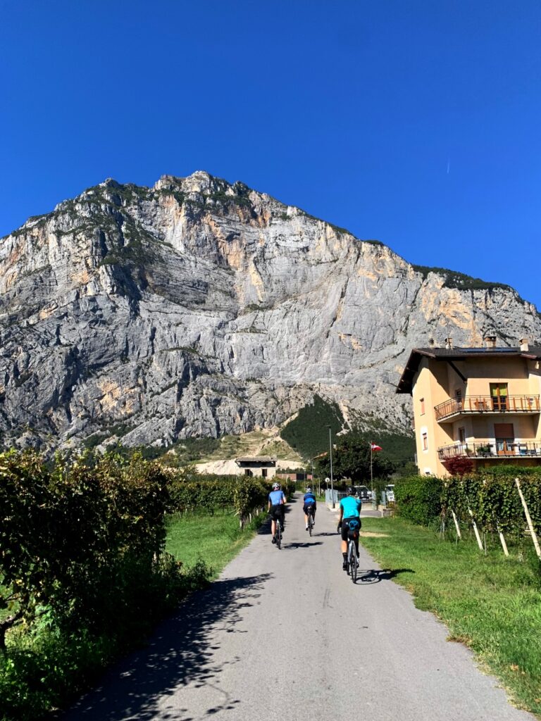 Fietsers door de Sarchevallei in Noord Italië met kliffen en wijngaarden en verder verlaten gebied.