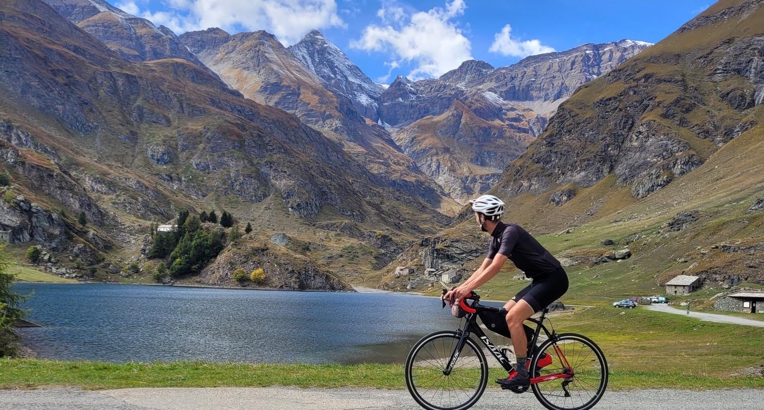 Rutger van Rudi Rides op de fiets langs het meer van Malciaussia tijdens een fietsvakantie in Italië, Piemonte. 