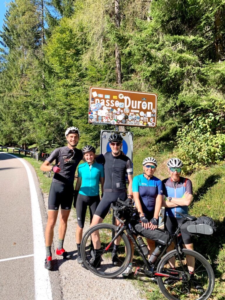 Groep wielrenners van Rudi Rides bovenop de Duronepas in de Italiaanse Alpen in de zon