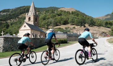 Fietsers op Alpe d'Huez Rudi Rides met kerk op achtergrond
