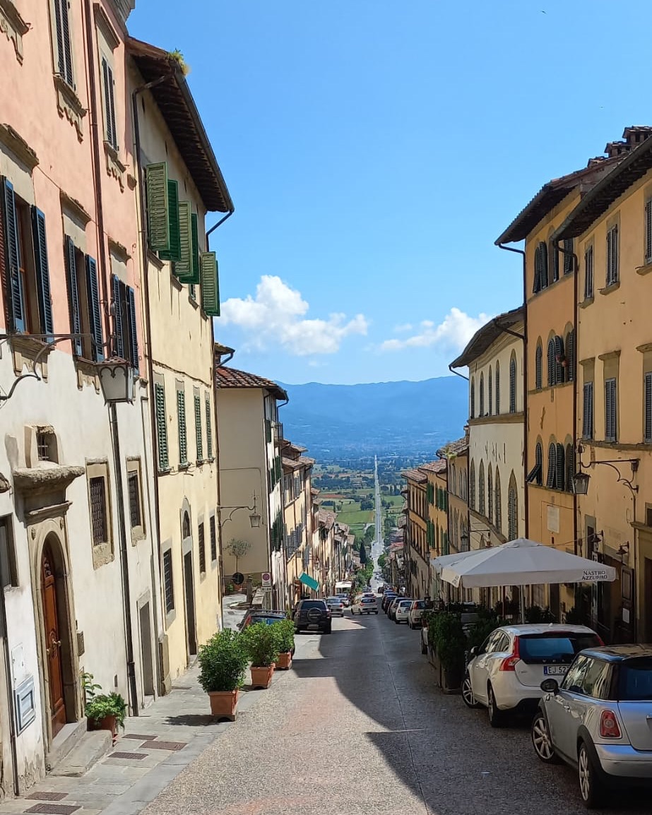 Straat in Anghiari in Italië met veel hoogteverschil en een doorkijk de verte in
