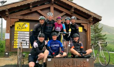 Groepsfoto Rudi Rides bovenop de Alpe d'Huez bij het bekende huisje met Tour de France bord