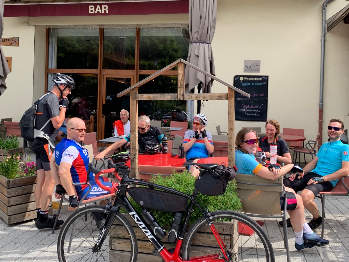 Terras met wielrenners en een fiets in La Meije tijdens een pauze. Franse Alpen Rudi Rides