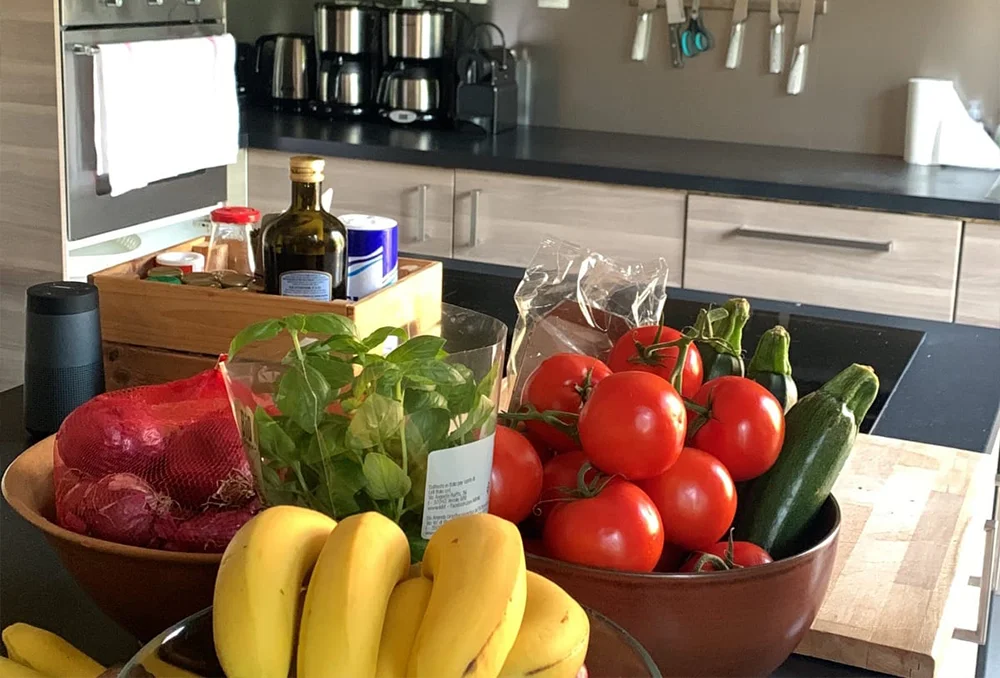 keuken in huisje Bourg d Oisans Verse ingrediënten uitgestald bij een kookeiland in een moderne keuken.