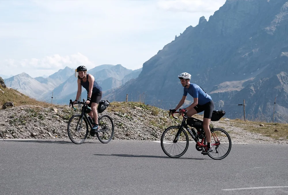 Frankrijk Alpen klimmen Galibier Lautaret Twee fietsers man en vrouw met bepakking op Galibier in Franse Alpen