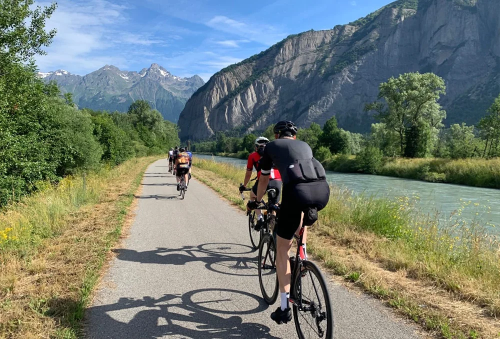fietsen langs romanche Fietsers op een fietspad langs een rivier de Romanche vlakbij Le-Bourg d'Oisans
