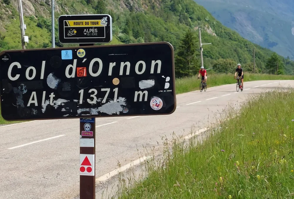 mijn eerste colbordje Col d'Ornon colbord met op achtergrond twee wielrenners.