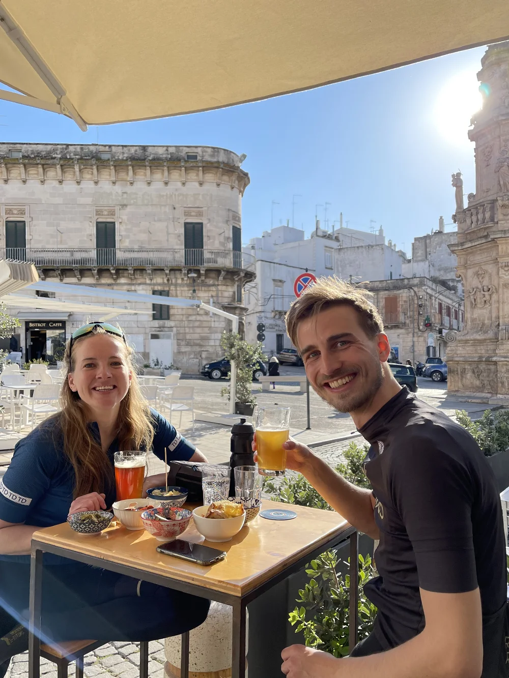 Fietsers drinken een biertje op een terras in Ostuni bij Drogheria Pugliese