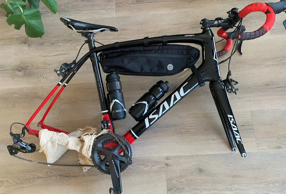 Fiets uit elkaar op de vloer Fiets zonder wielen en het zadel helemaal in. Zo kan de fiets in een transporthoes of fietskoffer mee in de trein.