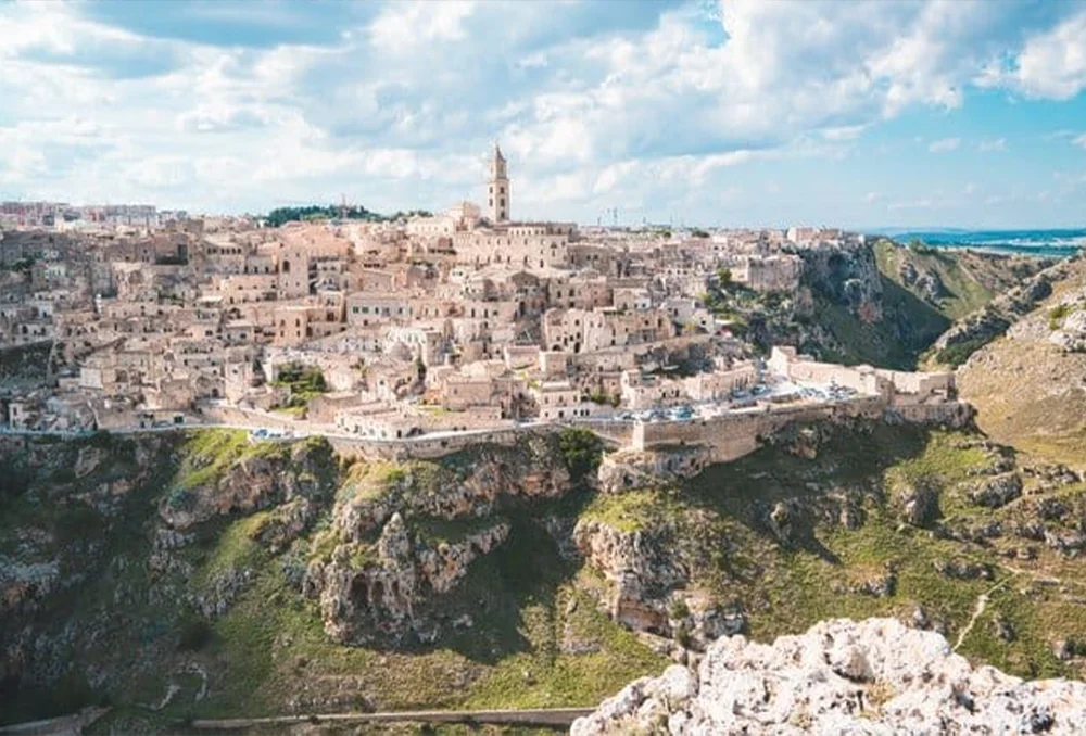 Italie_Zuid_Matera, Basilicata, Zuid Italie, vanaf de rotsen Stad in Zuid Italie met witte huizen gebouwd op rand van heuvel