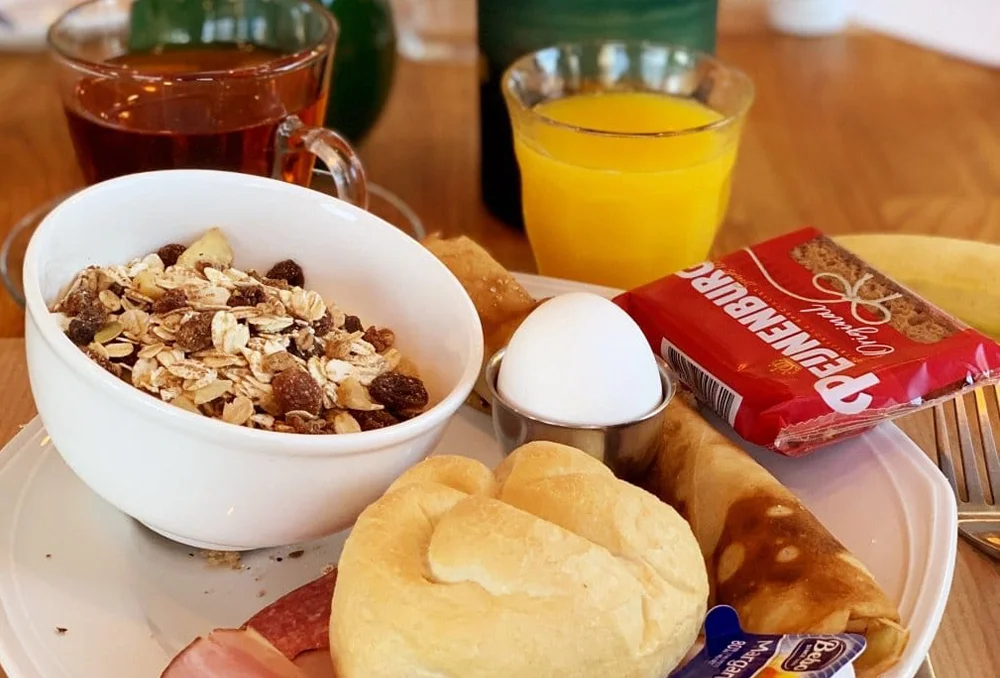 Eten_Nederland_Limburg_Brakke_berg_portret_ontbijt Vers ontbijt met muesli jus d'orange, kaiserbroodje, ham, Peijnenburg, koffie.