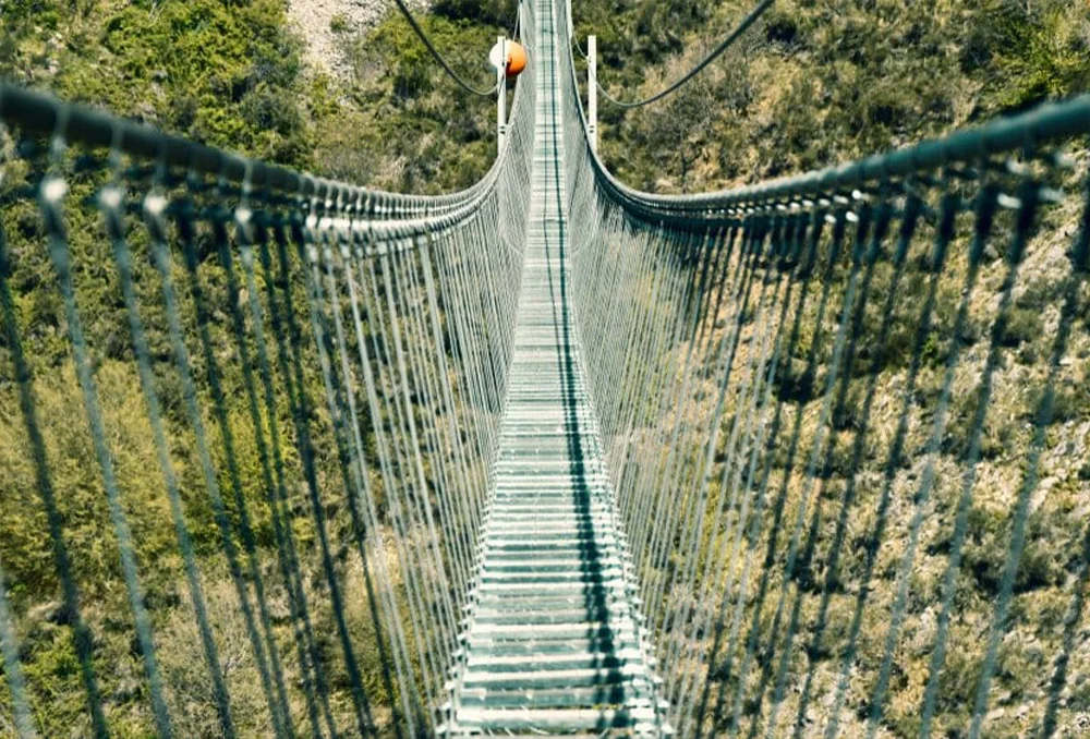 Italie_Zuid_Ponte alla Luna in Basilicata Een loopbrug met planken en zwarte touwen aan de zijkant om overheen te lopen