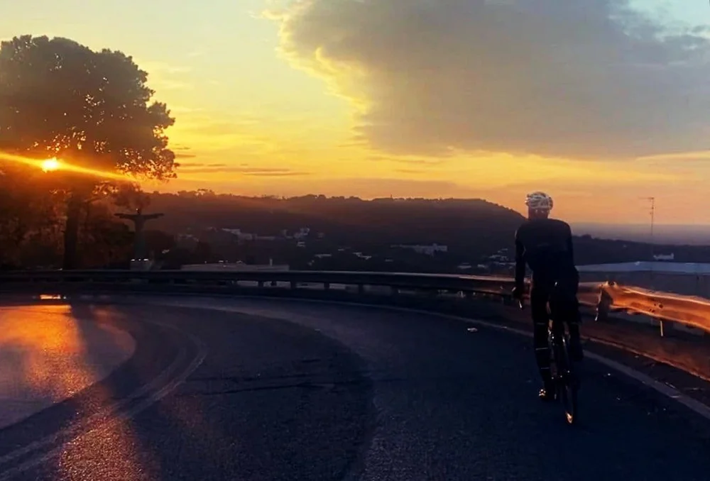 Zonsondergang op fietspad nabij Ostuni in Zuid-Italië Zonsondergang met fietser ergens in Puglia, Zuid-Italië op een verlaten weg nabij de B&B.