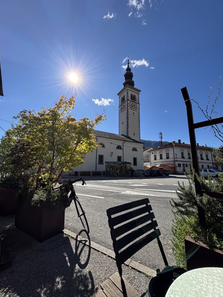 kobarid-stadscentrum-kerktoren Kobarid stadscentrum met kerktoren vanaf een terras in de zon
