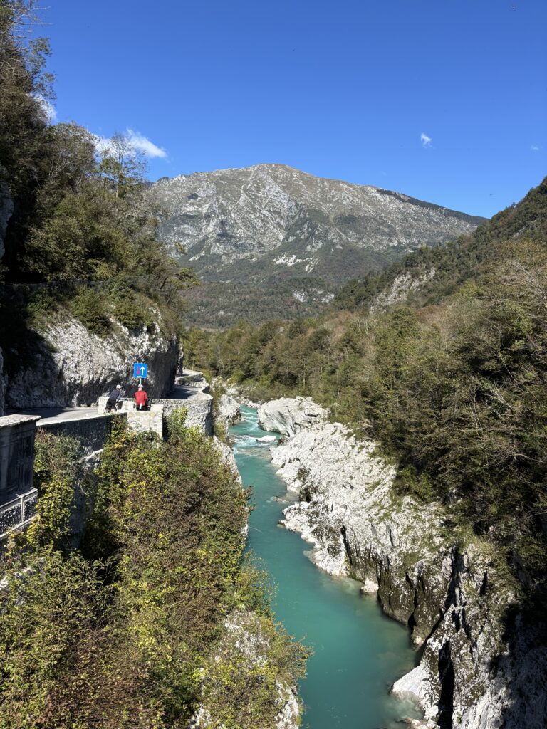 slovenie-kobarid-rivier-fietsers-blauwe-lucht Smaragdgroene Rivier de Soca nabij Kobarid met fietsers bij uitkijkpunt